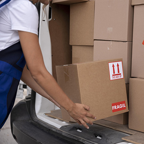 Une personne qui met des cartons de déménagement dans un camion pour un déménagement international