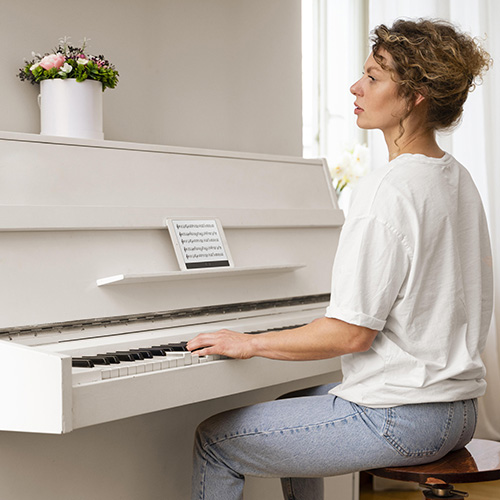 Une femme joue du piano qui doit être déménagé.